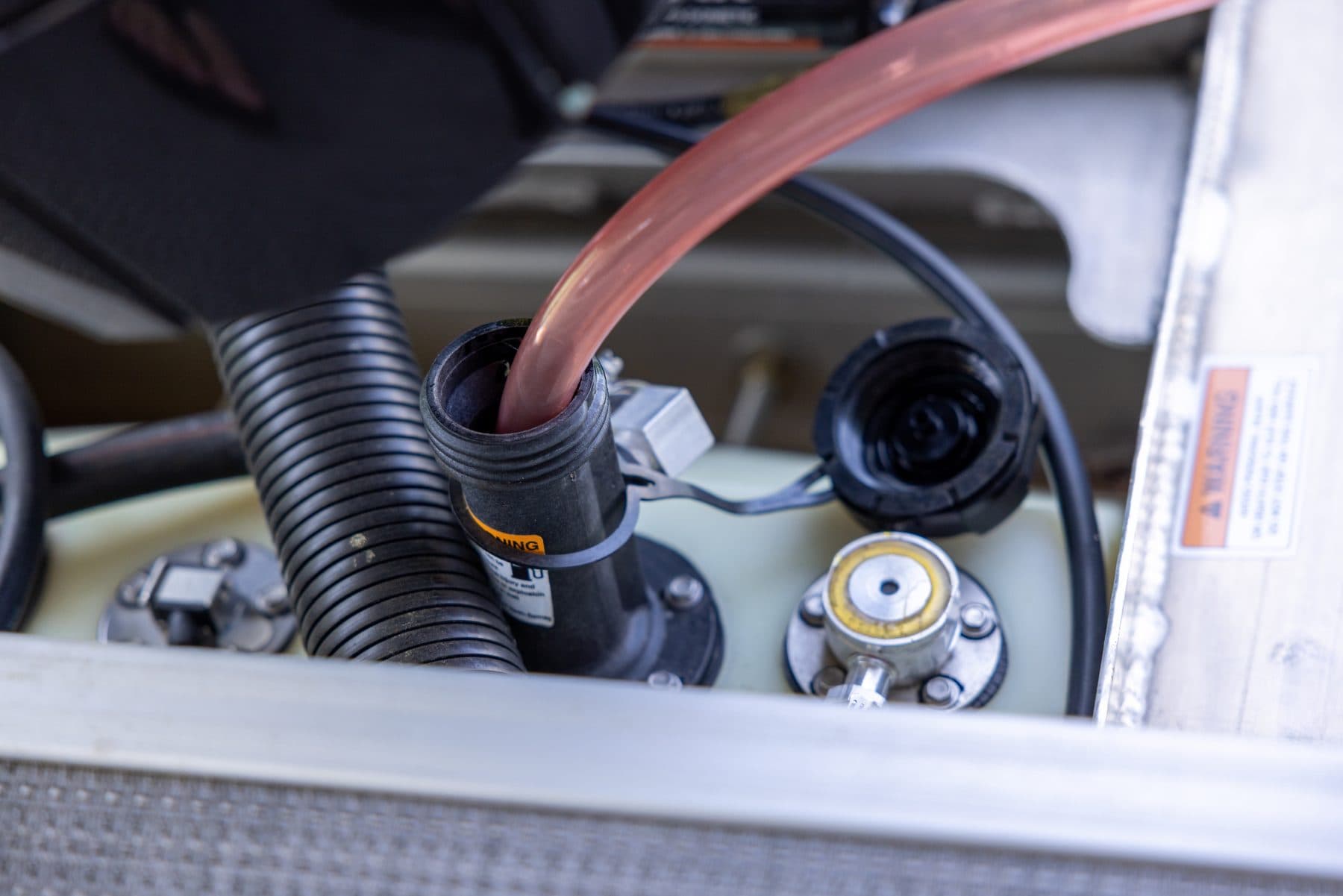 FlowPro siphon hose running into a pontoon boat's fuel filler